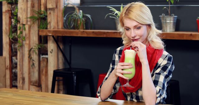 Woman Drinking Green Smoothie in Plant-Filled Café - Download Free Stock Images Pikwizard.com