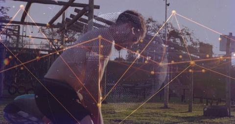 Fit young male pausing during intense training at outdoor calisthenics park