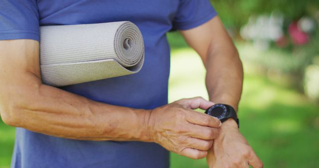 Senior Man Holding Yoga Mat Checking Smartwatch in Park - Download Free Stock Images Pikwizard.com