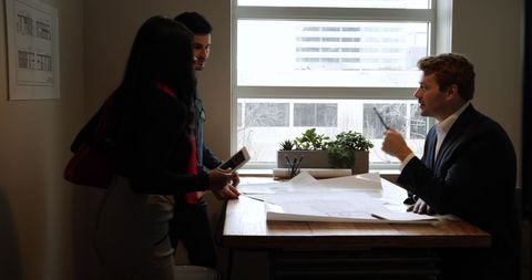 Architects Reviewing Plans During Office Meeting - Download Free Stock Images Pikwizard.com