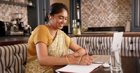 Indian Woman in Sari Remote Working at Home, Embracing Technology and Tradition