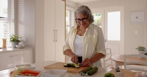 Senior woman preparing healthy meal in bright kitchen