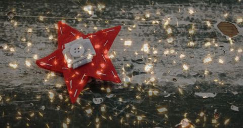 Festive Red Star with Ambient Golden Lights on Rustic Wood