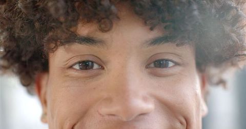 Close-Up Portrait of Curly-Haired Youth with Captivating Gaze