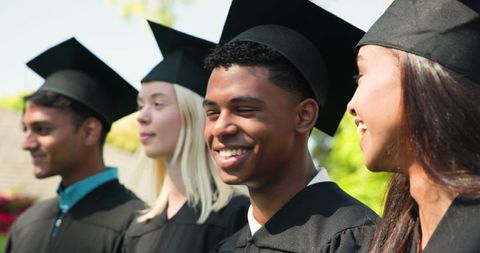 Diverse graduates celebrating outdoor academic achievement