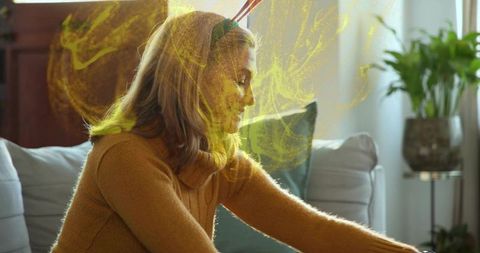 Cozy holiday moment leaning forward in mustard knit with antler headband and golden swirl