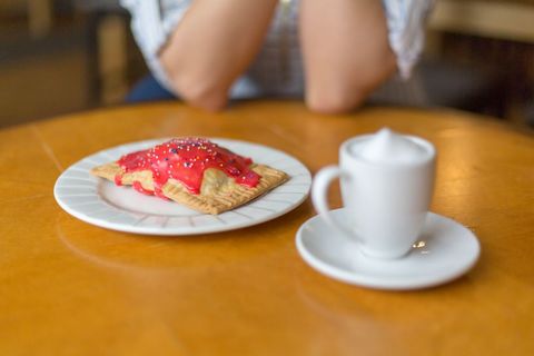 Warm Pastry with Red Icing and Coffee on Wooden Table
