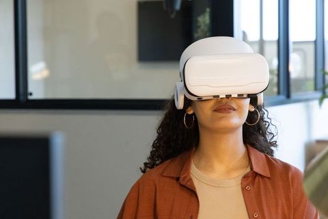 Young woman exploring virtual reality with white vr headset in contemporary office