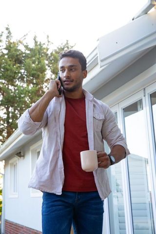 Young man on phone enjoying morning relaxation outdoors