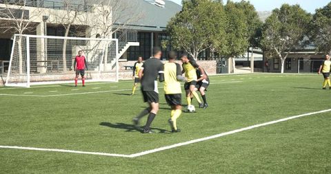 Competitive soccer match on grass field with focused athletes