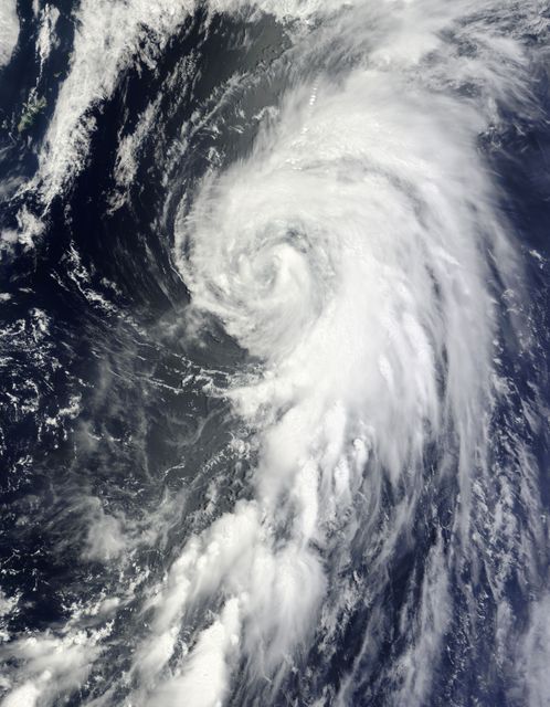 This stock photo captures Tropical Storm Yagi in the Western North Pacific Ocean, taken by the MODIS instrument aboard NASA's Terra satellite on June 10, 9:55 P.M. The image reveals a tightly-wrapped circulation with a clouded eye and northeastward-reaching storm bands. Useful for weather-related articles, educational materials on natural disasters, or climate studies.