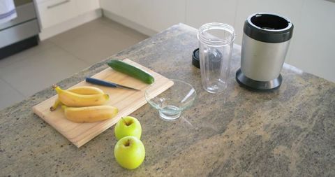 Fresh fruit and blender on granite countertop for smoothie prep in modern kitchen