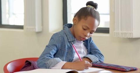 African american child writing in school classroom