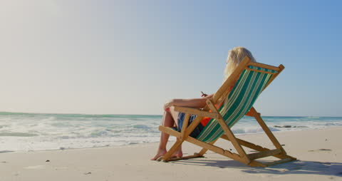Woman Relaxing on Beach Lounger Overlooking Ocean
