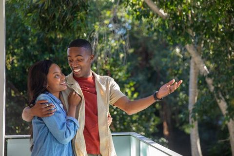 Happy African American Couple Embracing on Sunny Tree-Lined Balcony