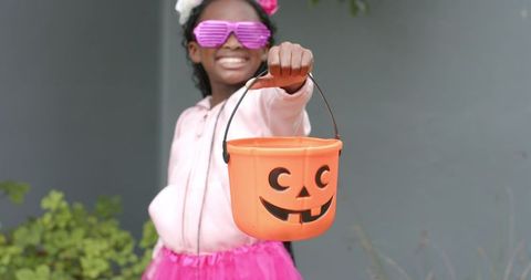 African American Girl Holding Jack-O'-Lantern Candy Bucket Wearing Pink Tutu and Shutter Shades