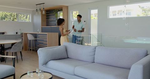 Happy Couple Discussing Paperwork in Modern Living Room