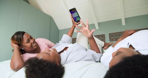 Friends laughing together while enjoying smartphone