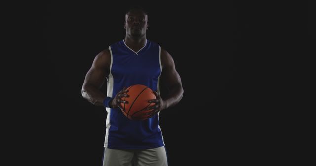 Strong Basketball Player Holding Ball Isolated on Black Background - Download Free Stock Images Pikwizard.com