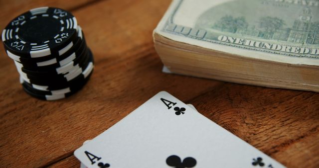 Close-up of playing cards, dollar and casino chips on poker table in casino