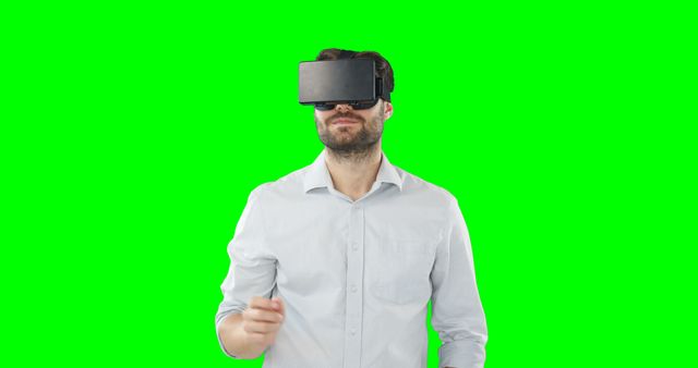 Man engaging with virtual reality headset against green screen background. This can be used for technology-related content, promoting immersive experiences or presentations, novelty events, and virtual reality innovations. Ideal visually to portray futuristic concepts and cutting-edge technology.