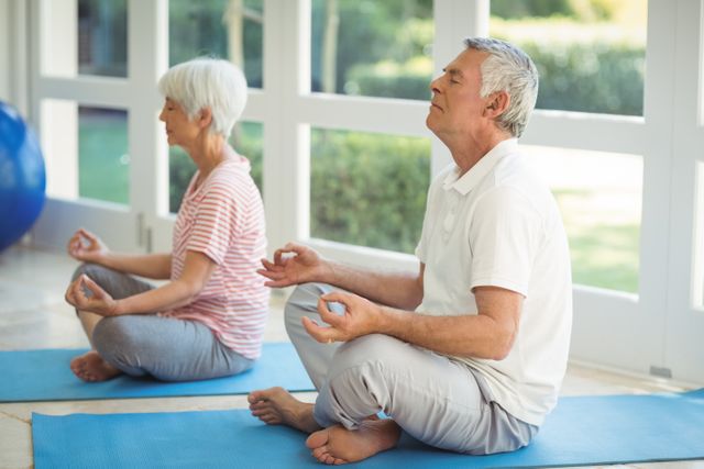 Senior Couple Meditating on Yoga Mats at Home - Download Free Stock Photos Pikwizard.com