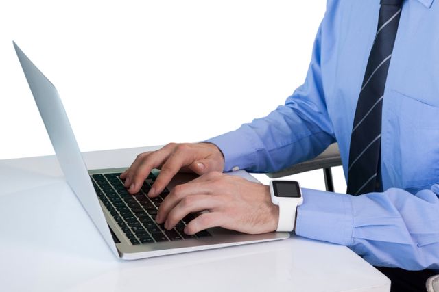 Mid section of businessman using laptop while sitting at table against white background