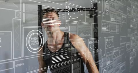 Athletic man examining futuristic transparent data interface hud in minimalist workspace