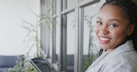 Cheerful Businesswoman Using Tablet in Modern Office