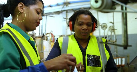 Two african american women collaborating in industrial setting