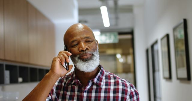 African American businessman talking on phone in modern office hallway - Download Free Stock Images Pikwizard.com