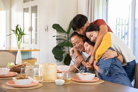 Happy Multi-generational Family Gathered Around Dining Table