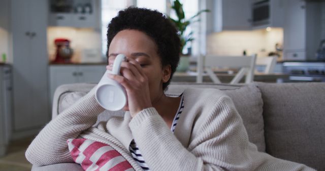 Woman Relaxing on Cozy Couch at Home while Drinking Coffee - Download Free Stock Images Pikwizard.com