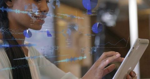 Professional woman interacting with tablet and augmented data visualization in coworking space