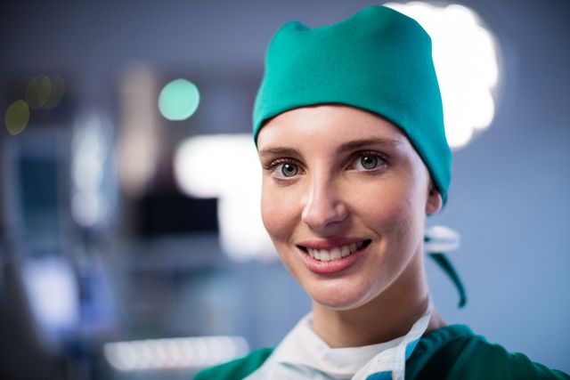 Female surgeon smiling confidently in an operating room. Ideal for use in healthcare promotions, medical articles, hospital websites, and educational materials about surgery and medical professions.