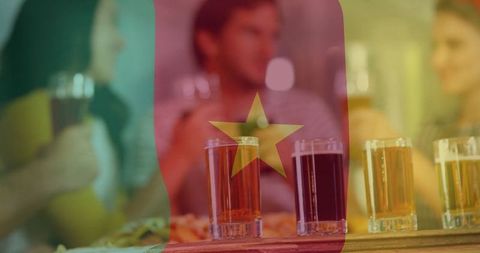 Friends Toasting Beer with Cameroon Flag Overlay in Rustic Pub Setting