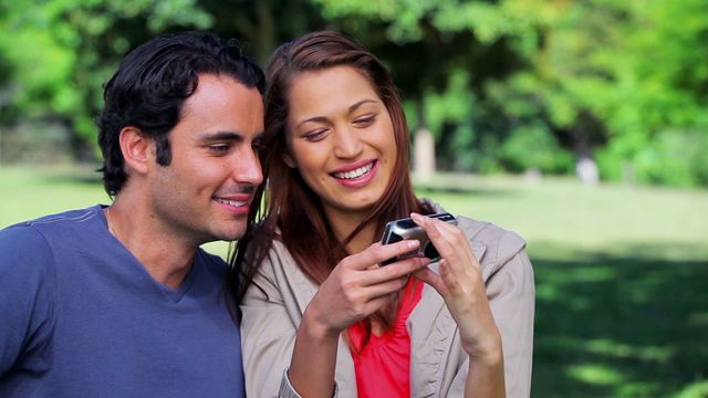 Couple enjoying a moment while taking a selfie in a picturesque countryside setting. Perfect for illustrating themes of happiness, technology in relationships, or leisure activities in nature. Great for use in lifestyle advertisements, blogs about relationships, or travel content showcasing outdoor bliss.