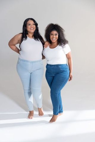 Confident plus-size friends wearing white tops and denim embracing body positivity