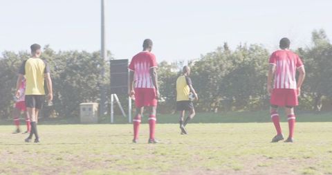 Youth soccer training showcasing Hispanic player holding ball in yellow bib on grassy pitch