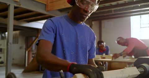 Craftsmen shaping wood on lathe in workshop