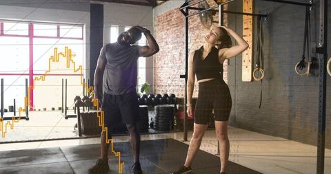 Partners doing neck and shoulder stretches in industrial gym pull-up rig for mobility