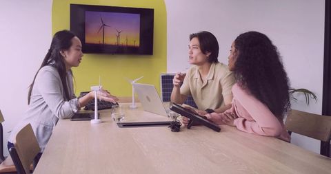 Team discussing renewable energy plans with scale models