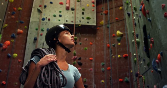 Ideal for websites and magazines focused on rock climbing, fitness training, or women's sports activities. Can be used in promotions or blogs discussing indoor climbing gyms, adventure sports, and safety measures in climbing.