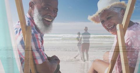 Senior Couple Relaxing Beachside in Deck Chairs
