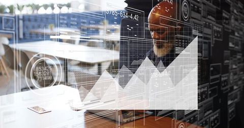 Mature manager analyzing digital business charts on laptop with dashboard overlay