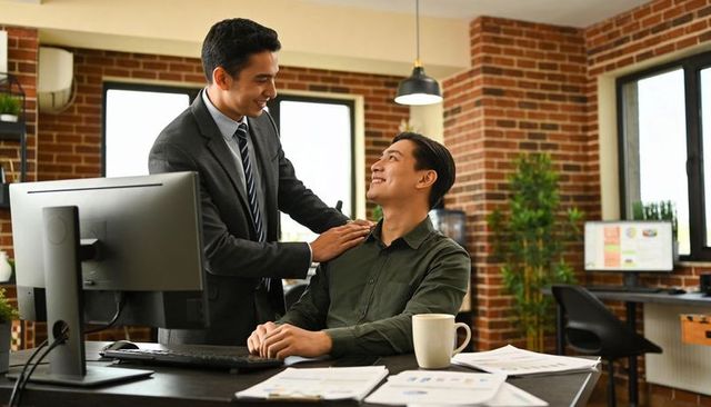 Business leader mentoring colleague in modern brick office showing teamwork and leadership