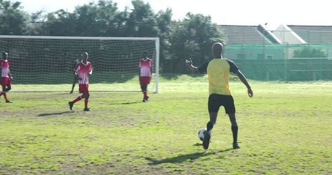 Soccer Player Controlling Ball Near Goal on Sunny Day