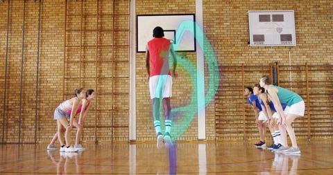 Teen basketball player leaping for jump shot with neon motion trail in school gym