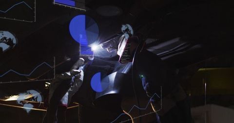 Female Welder Welding Under Vehicle with Torch and Helmet, Industrial Workshop Night Scene