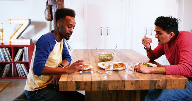 Gay couple interacting with each other while having meal at home